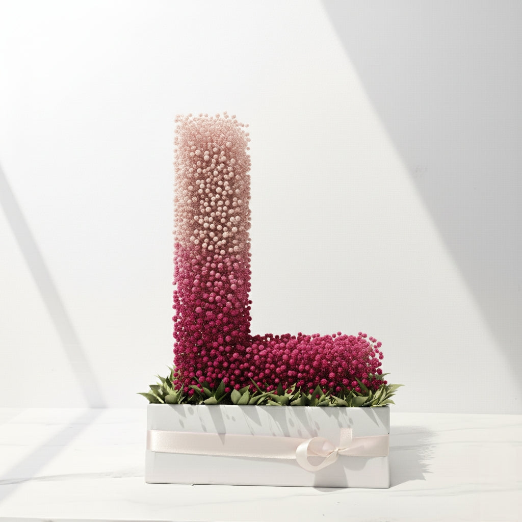 Decorative letter 'L' made of pink and red flowers on a white background.  Fresh flower bouquet