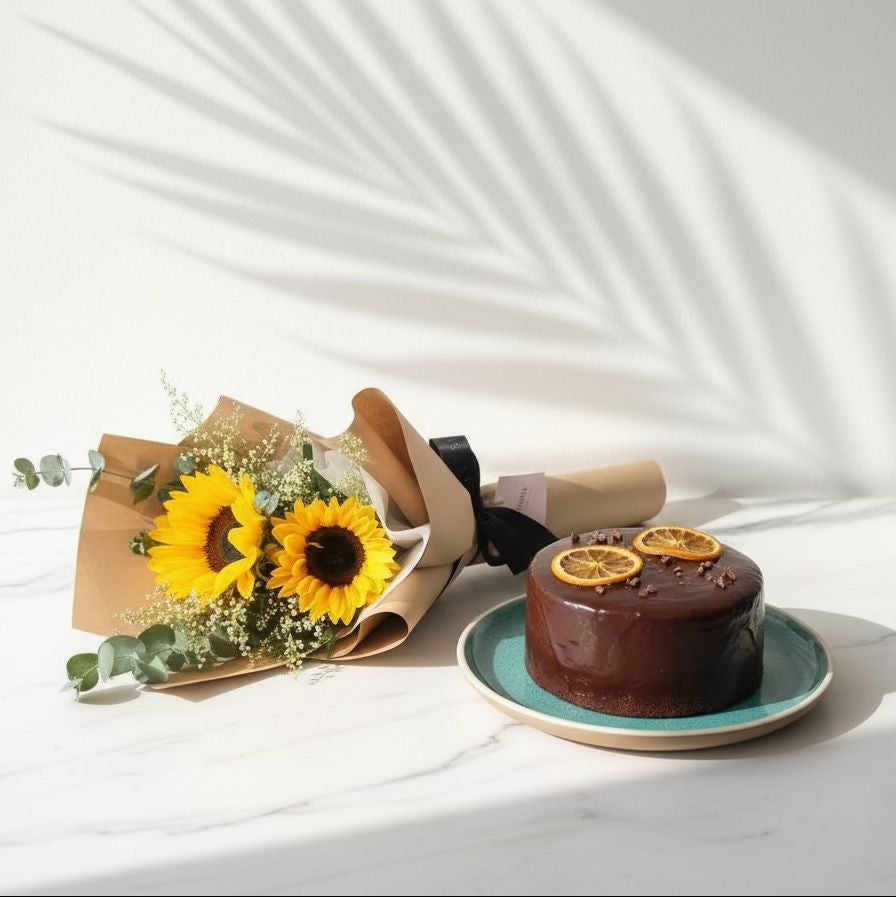 Chocolate cake with lemon slices on a white surface with sunflowers. Bento Cake and Flower Bouquet