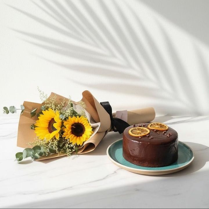 Chocolate cake with lemon slices on a white surface with sunflowers. Bento Cake and Flower Bouquet