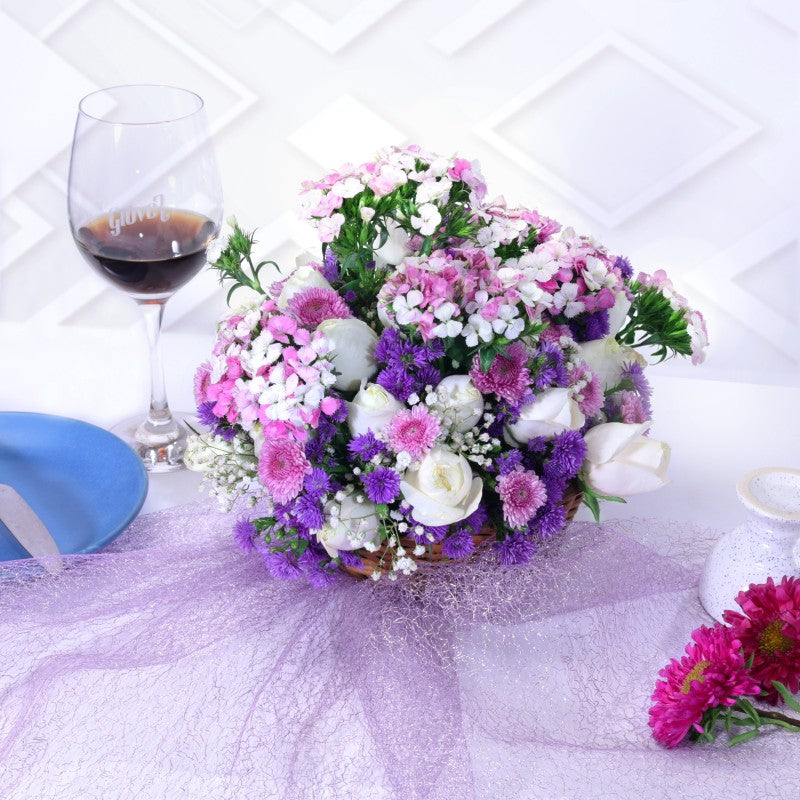 Bouquet of flowers with a glass of wine on a textured surface