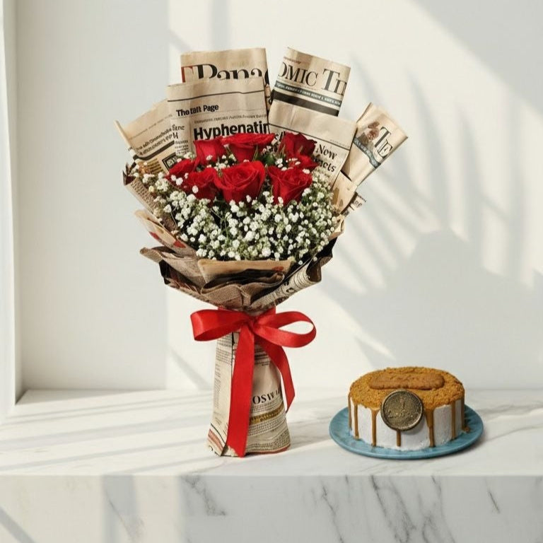 Bouquet of red roses and baby's breath wrapped in newspaper with a red ribbon, next to a small cake on a white surface. Bento Cake and Flower Bouquet
