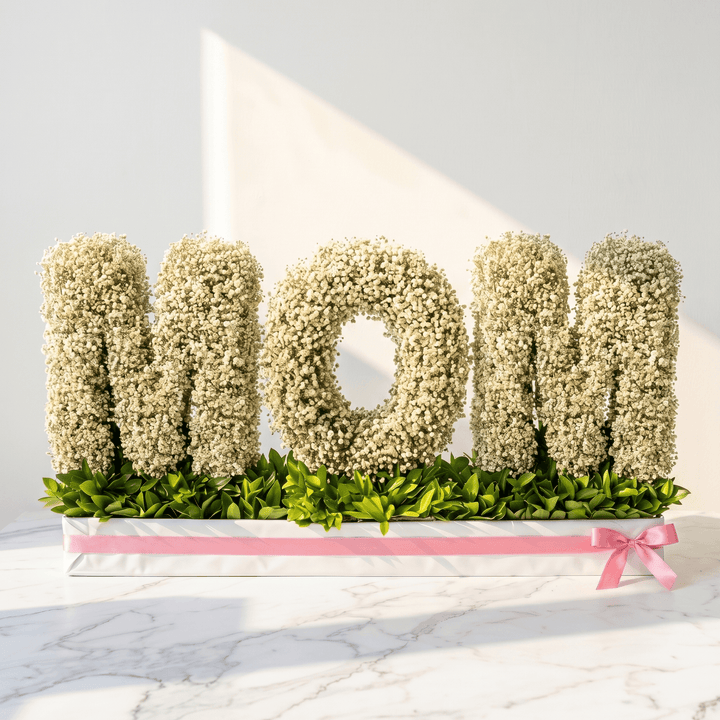 Floral arrangement spelling 'MOM' on a white background