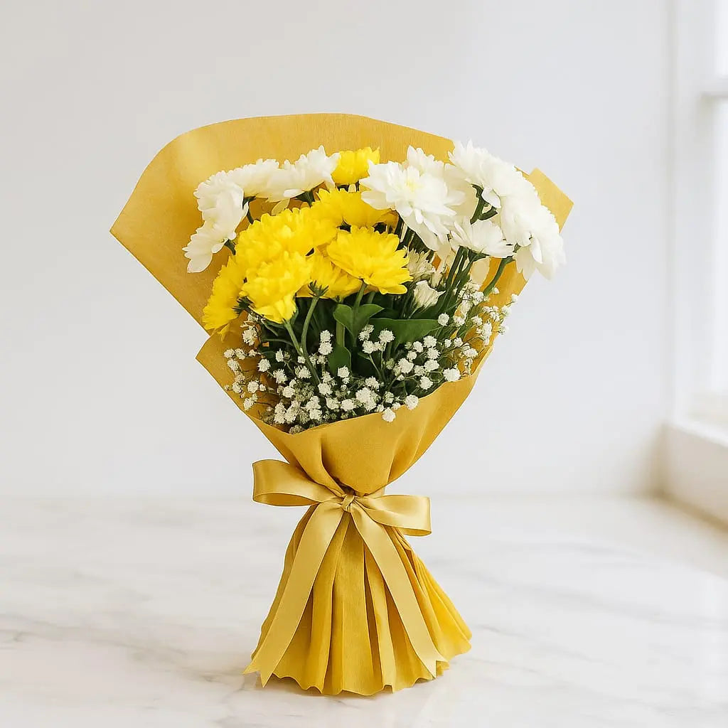 Bouquet of yellow and white flowers wrapped in yellow paper with a bow on a light background