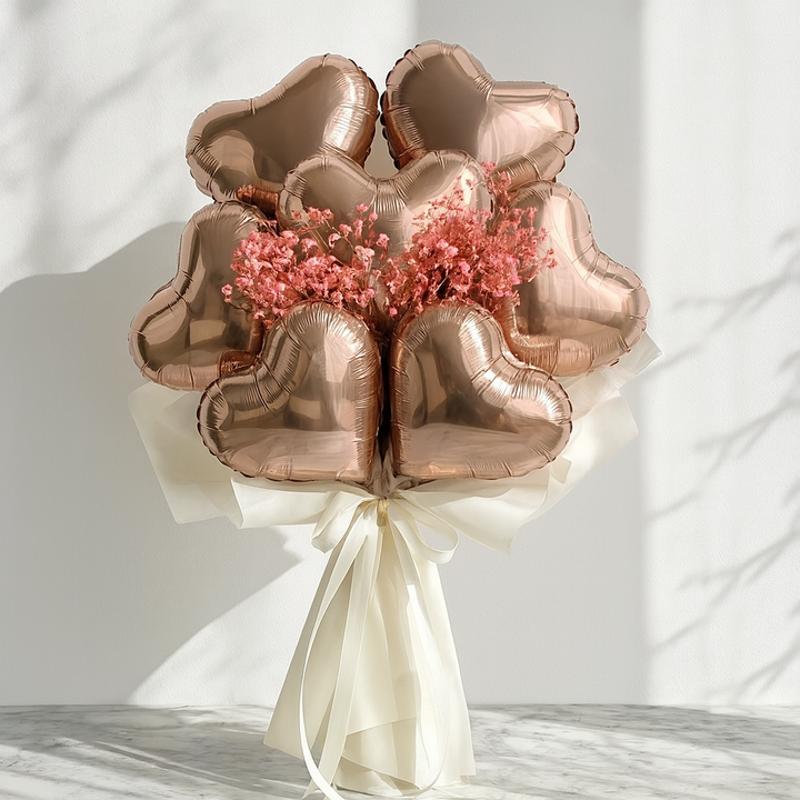 Bouquet of rose gold heart-shaped balloons with pink flowers on a white background. fancy bouquet