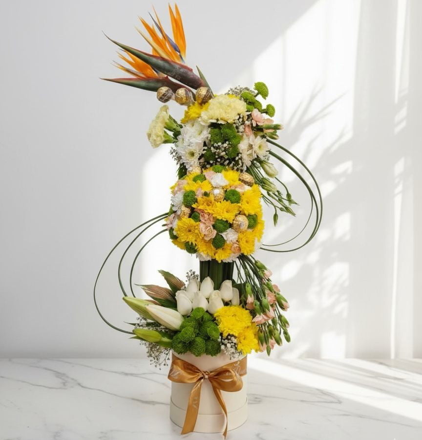 Tall floral arrangement with yellow and green flowers on a white background