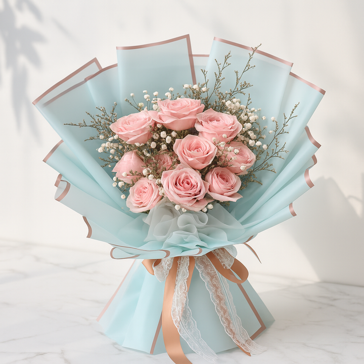 Bouquet of pink roses wrapped in light blue paper with a lace ribbon on a white background. flower hampers