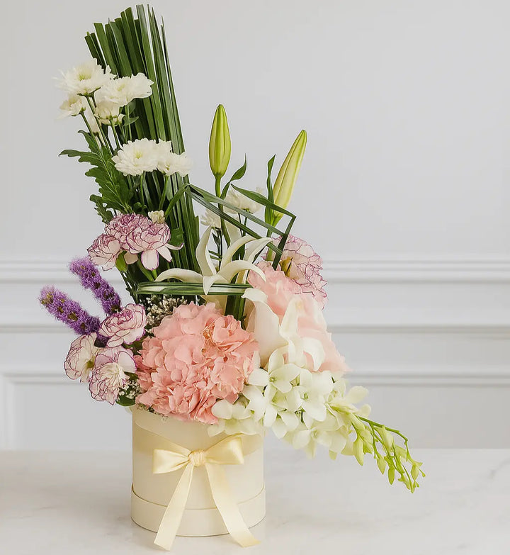 Floral arrangement in a box with a decorative bow on a light background