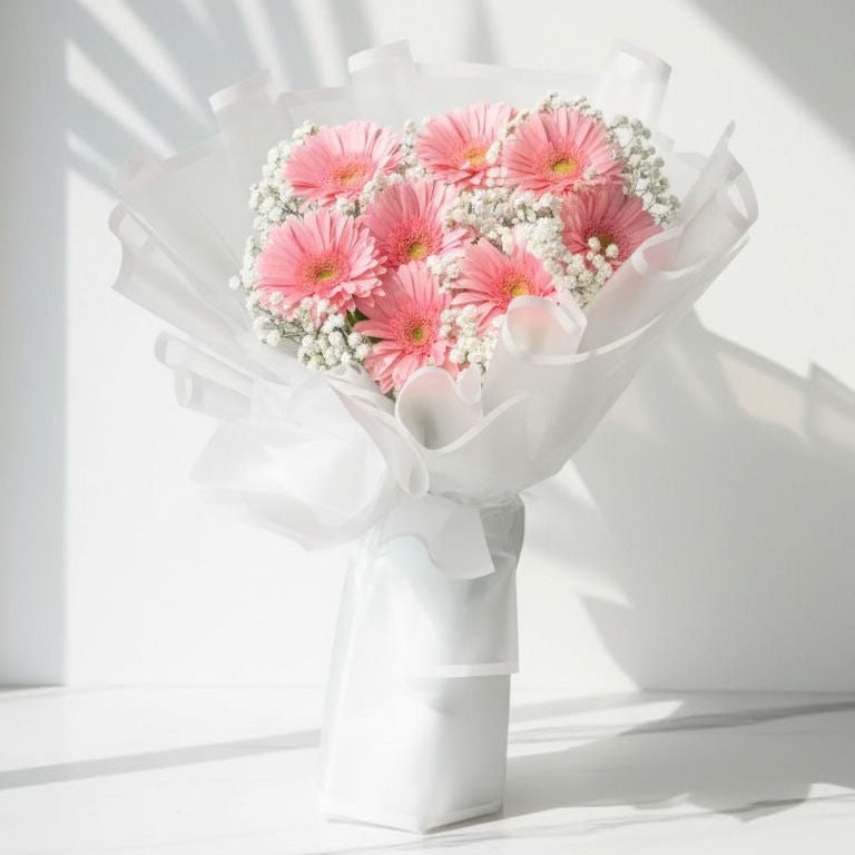 Bouquet of pink flowers in a white vase on a light background