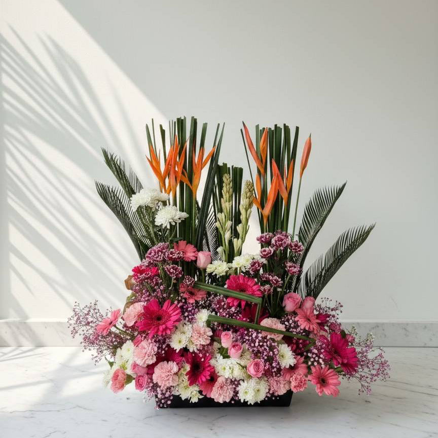 Colorful floral arrangement with pink, white, and green flowers on a marble surface.