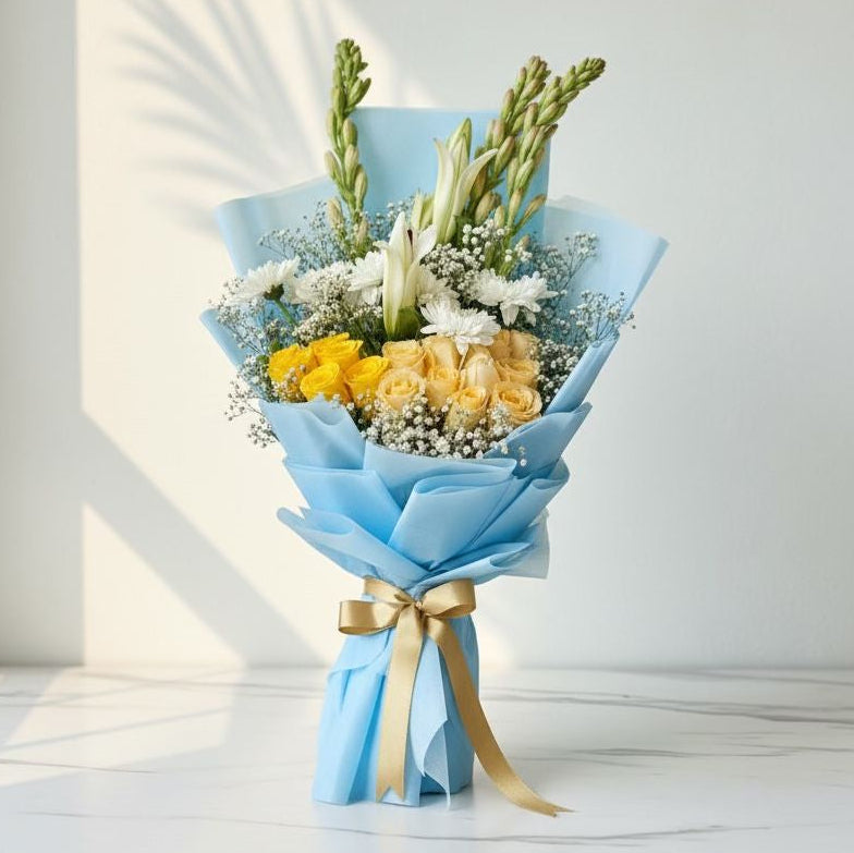 Bouquet of flowers wrapped in blue paper with a gold ribbon on a light background