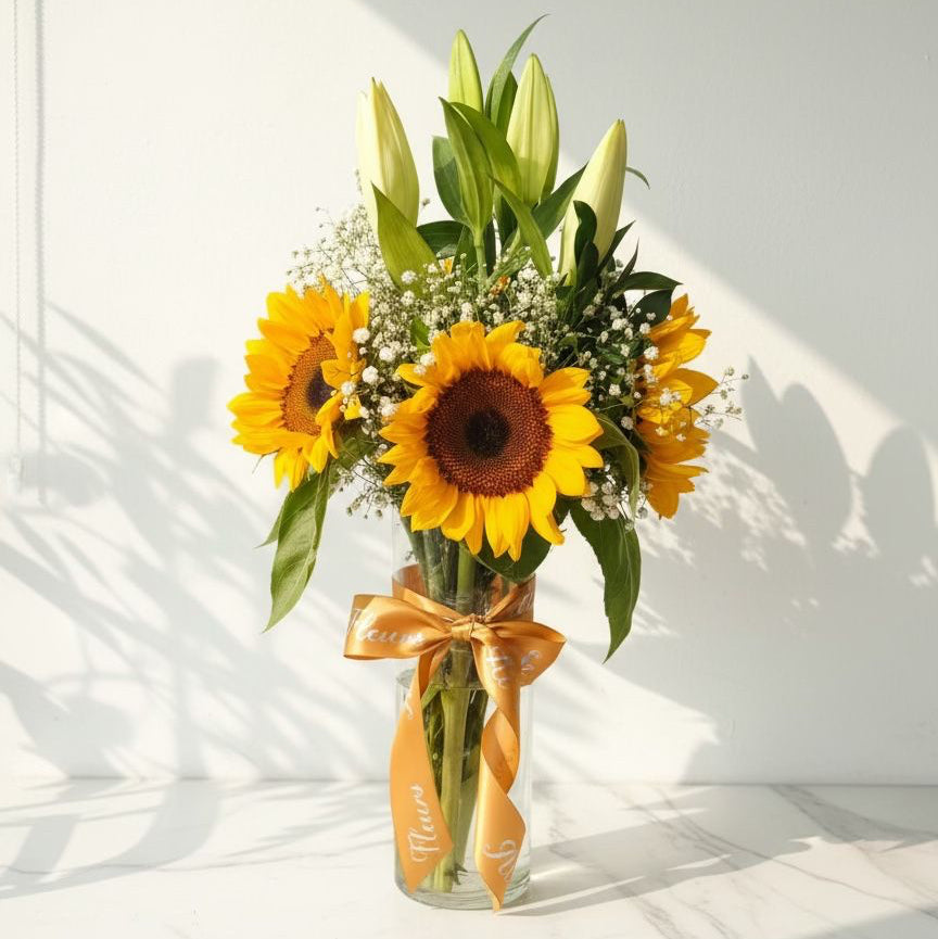 Bouquet of sunflowers in a clear vase with a gold ribbon on a white surface.  Fresh Flowers