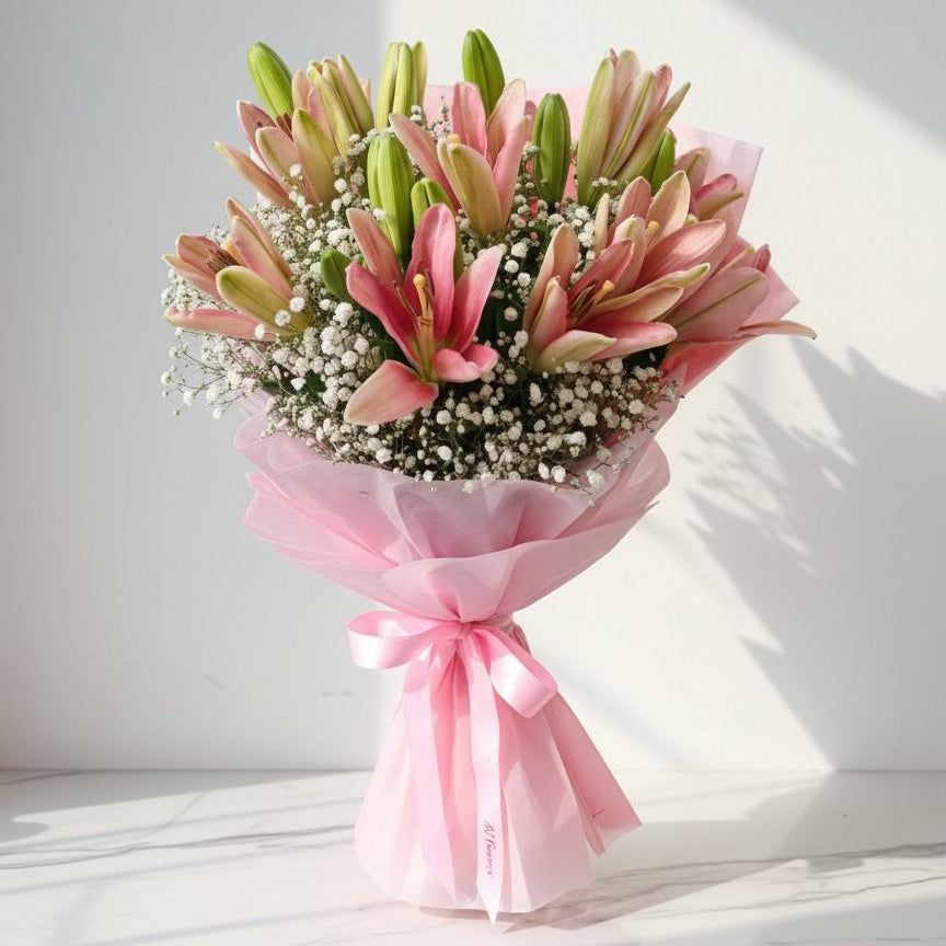Bouquet of pink and green flowers wrapped in pink paper with a bow on a white background