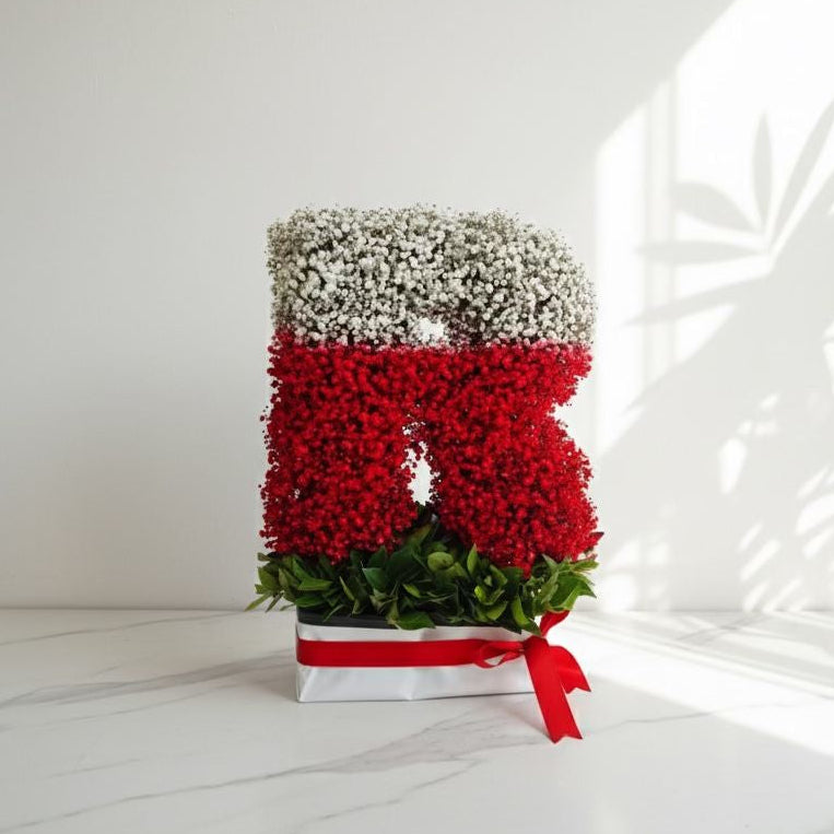 Decorative arrangement with red flowers and silver berries on a white background