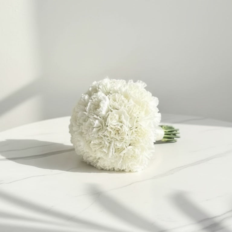 Bouquet of white flowers on a light surface with soft shadows wedding bouquet