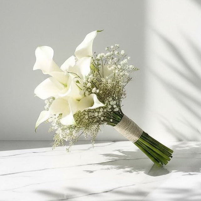 Bouquet of white flowers with greenery on a white surface with shadows wedding bouquet bridal 