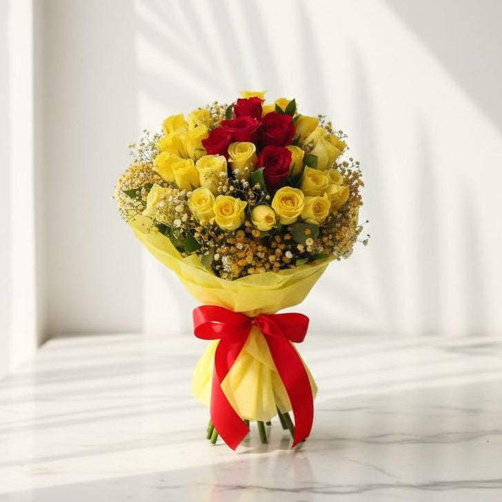Bouquet of yellow and red roses with a red bow on a white background