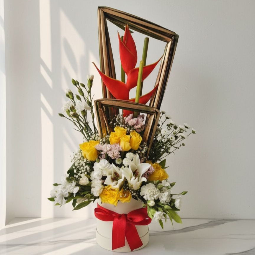 Floral arrangement with a red ribbon and a decorative frame on a white surface. Fresh Flower Bouquet