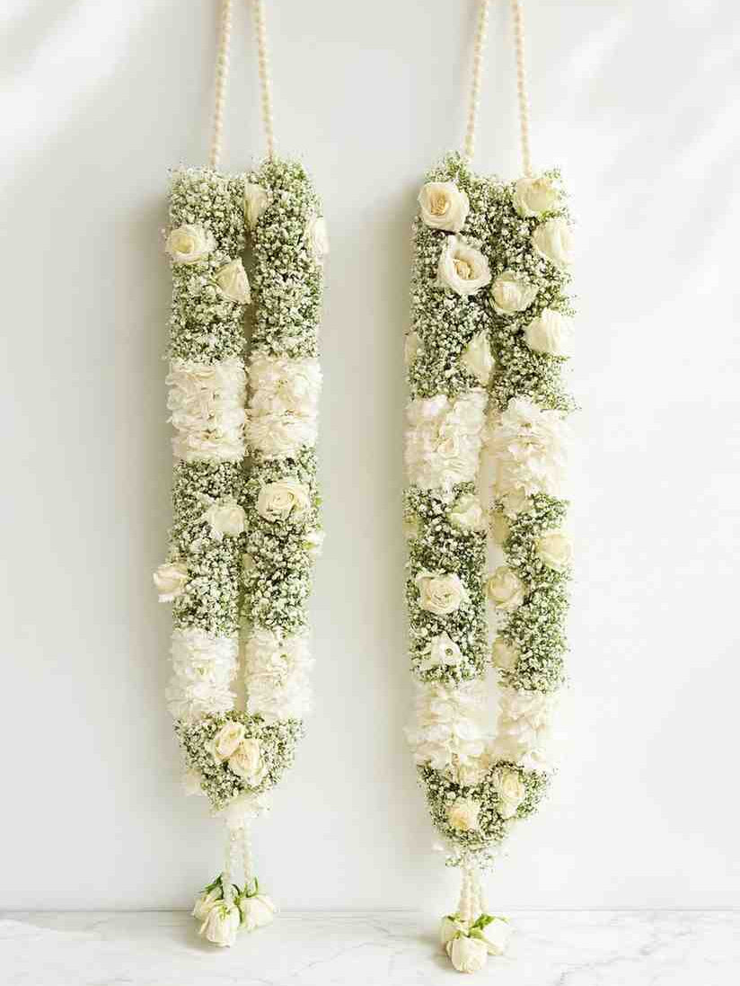 Two floral Garland hanging against a white background. Fresh Flowers