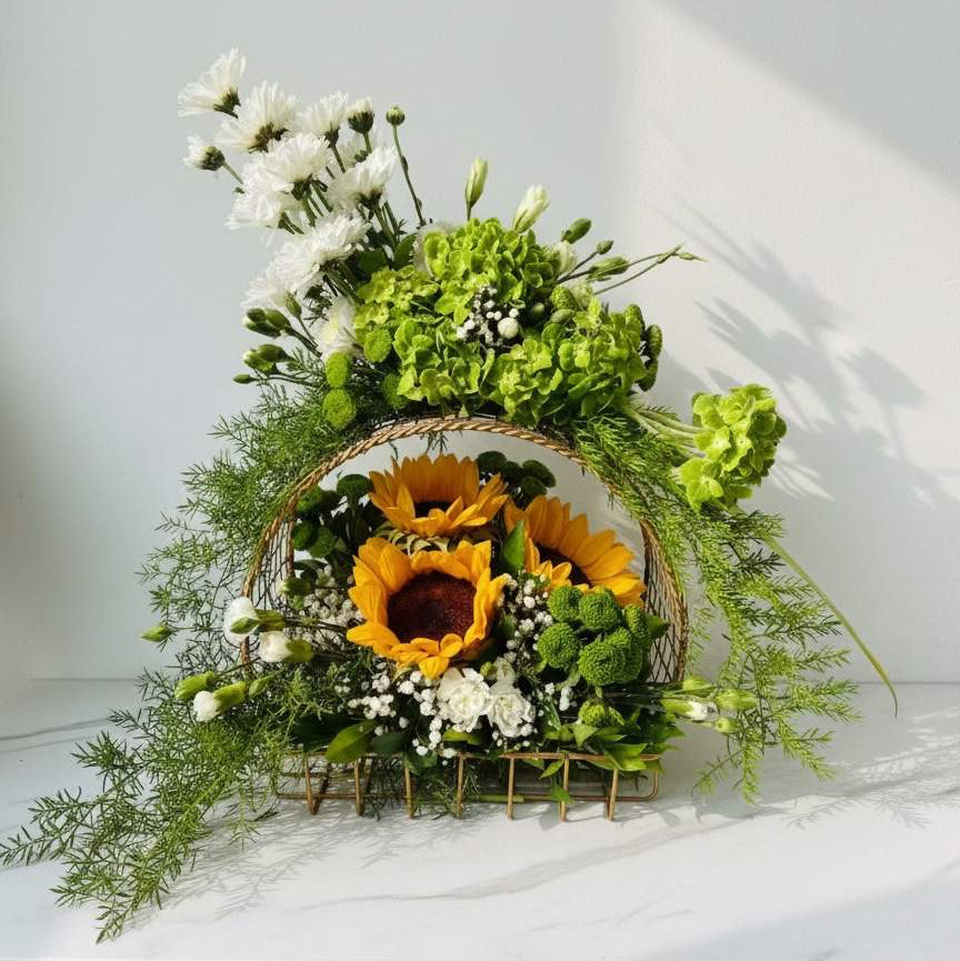 Bouquet of sunflowers and greenery in a woven basket on a white background